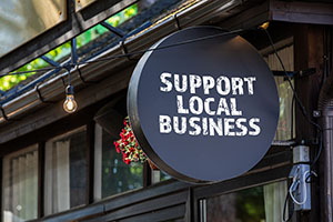 Support local business sign **Local Restaurants & Businesses:** Complementary businesses (e.g., waterfront eateries, local tour operators, outdoor gear shops) aiming to enhance their customer offerings.